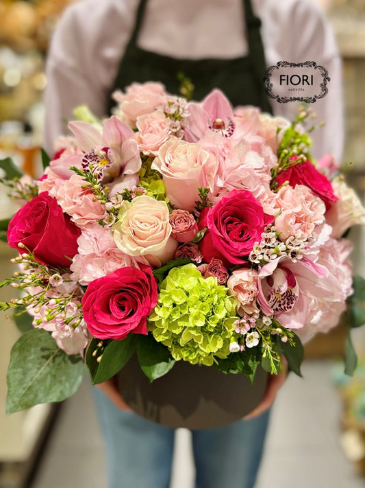 Oakville Florist. Luxury Valentine's Day floral arrangement with pink roses, Cymbidium orchids, and green hydrangea in a matte chocolate ceramic vase. 