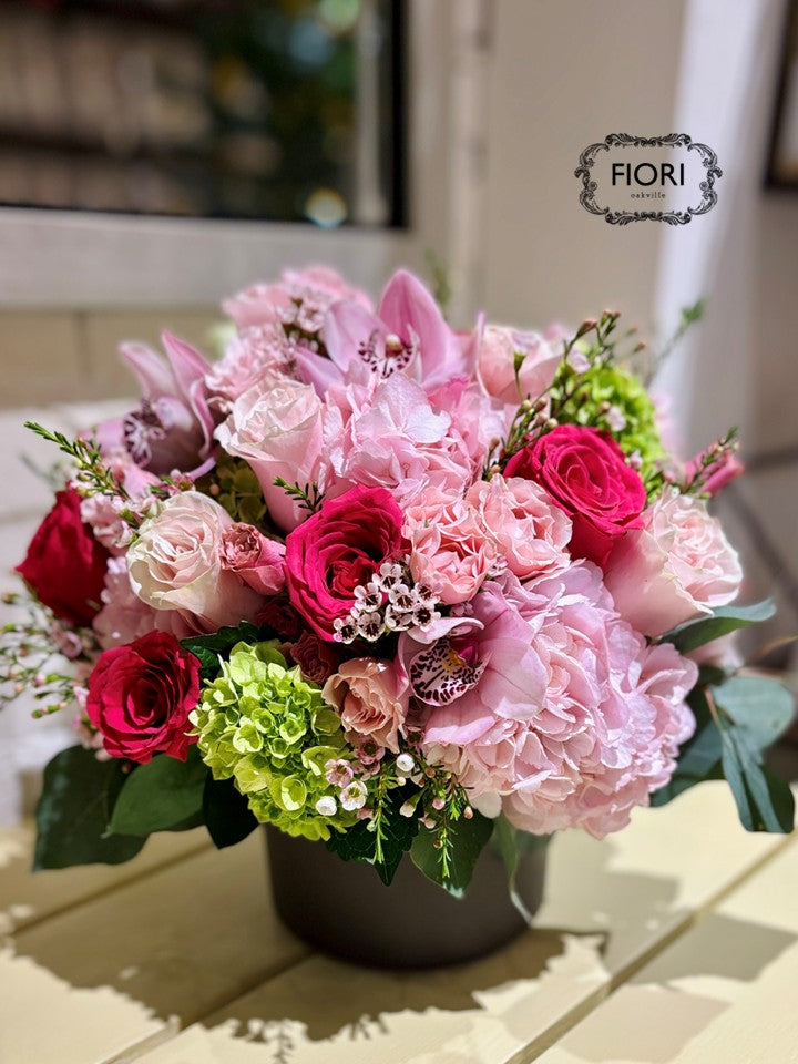 Oakville Flower shop. Luxury Mother's Day flower arrangement "Dolce Mamma" featuring hot pink roses, Cymbidium orchids, and green hydrangea in a chocolate ceramic vase. Oakville online Delivery. 